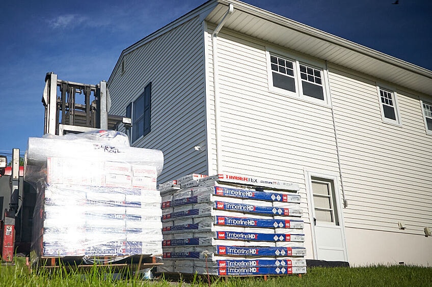 GAF Timberline HDZ shingle bundles next to a Habitat for Humanity home