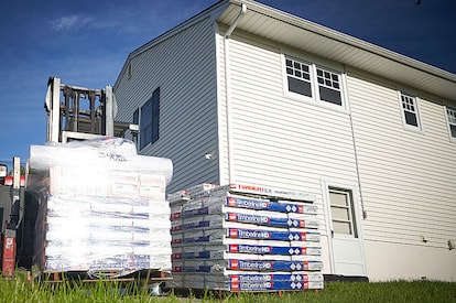 GAF Timberline HDZ shingle bundles next to a Habitat for Humanity home