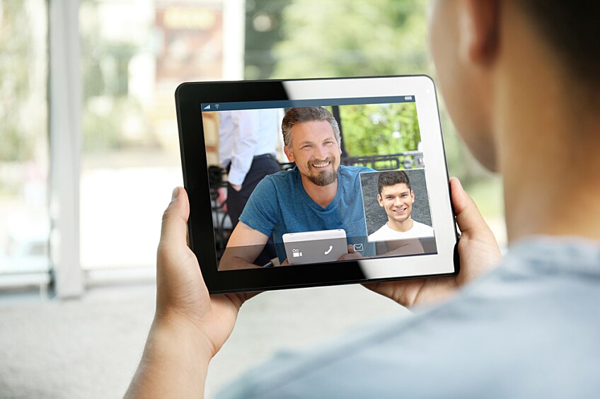 A close-up of a tablet being used for a business video call.