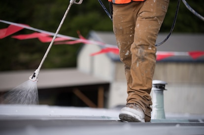 A roofer applying a roof coating