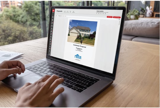 Couple looking at woman's tablet outside of a home.