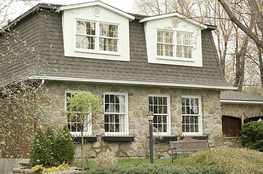 Home with a dark shingled mansard roof.