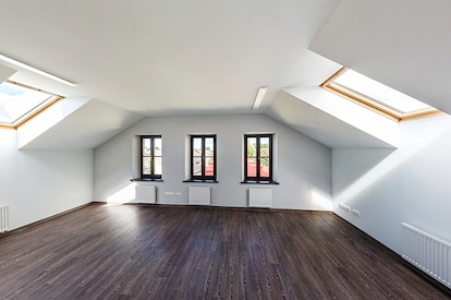 Empty unfurnished loft mansard room interior with wooden columns and wet concrete floor on roof leve