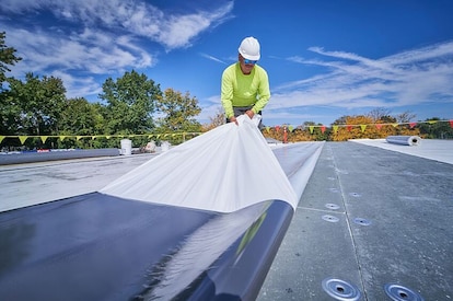 Self-adhered TPO being installed on commercial roof