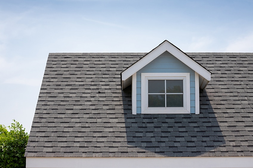 Asphalt roof shingles with sun beaming on the roof