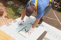 A roofer installs GAF Deck-Armor™ Premium Roof Deck Protection underlayment