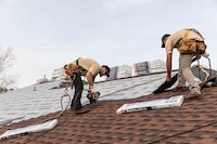 Two roofers installing GAF shingles.