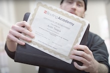 GAF Roofing Academy Graduate holds up his certificate of achievement.