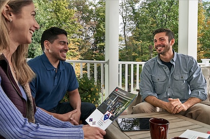 A contractor reviews roof warranty options with potential clients.