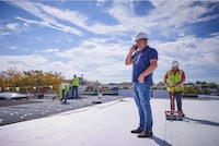 An architect inspects the roof of a commercial building