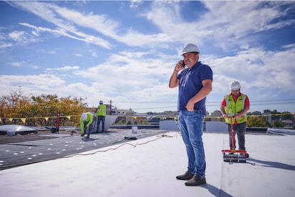 An architect inspects the roof of a commercial building