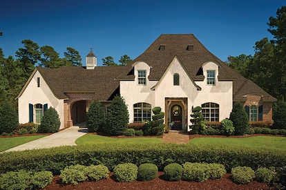 A large house with dark roofing shingles.