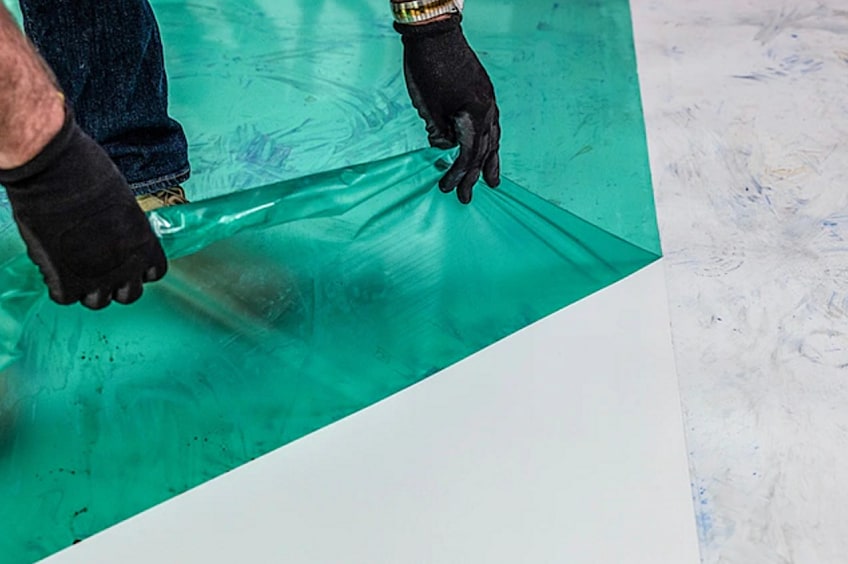 A contractor installs a roofing membrane.