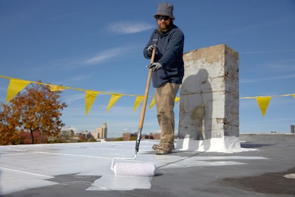 Contractor using a roof coating on a commercial roof