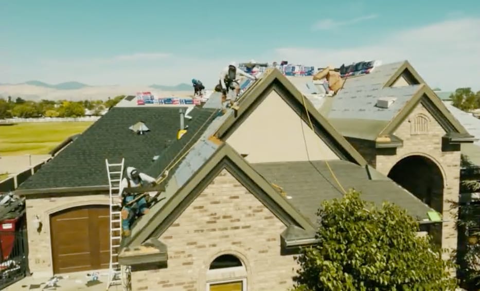 8750ca7b-00ee-488f-b91e-194b82fe2dcc Roofers installing GAF Timberline HDZ® shingles on a residential home to ensure durability against harsh Utah canyon winds and UV exposure.