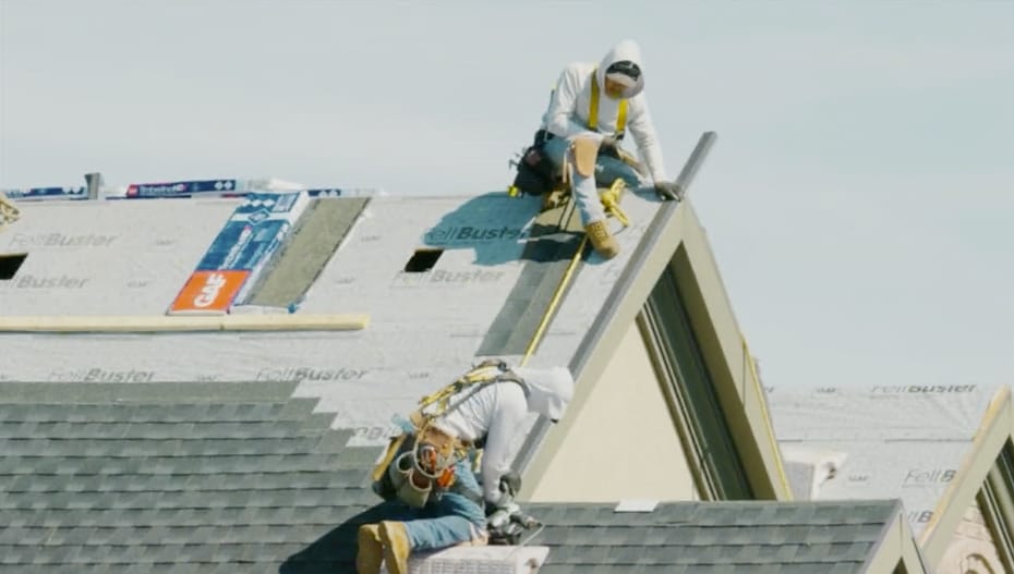 a399e344-2e6e-42e4-a421-06b90e684d41 Two roofing technicians in safety harnesses installing GAF Timberline HDZ® shingles and FeltBuster underlayment on a residential roof in Utah