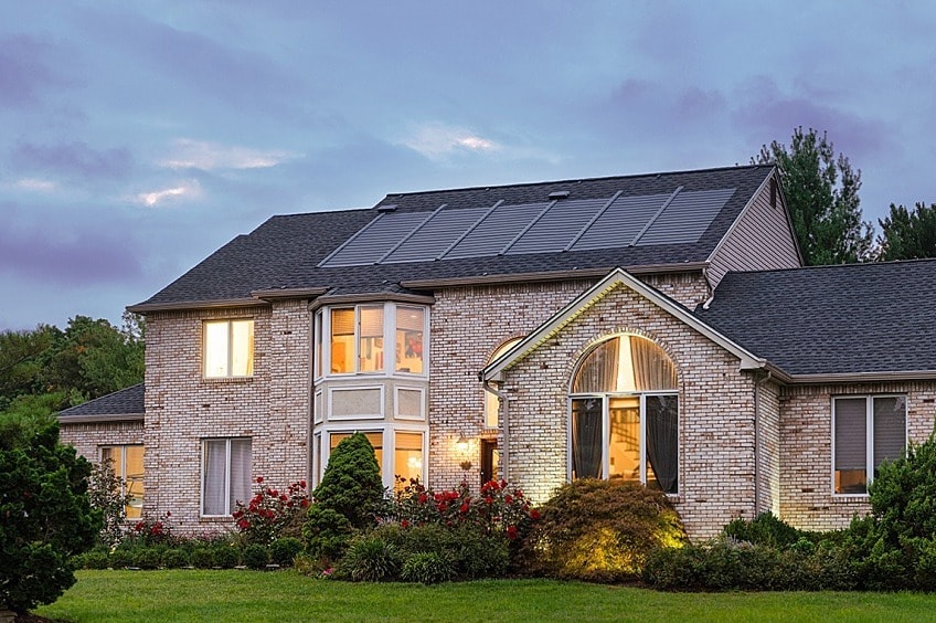 Sun shines over a roof with solar shingles.