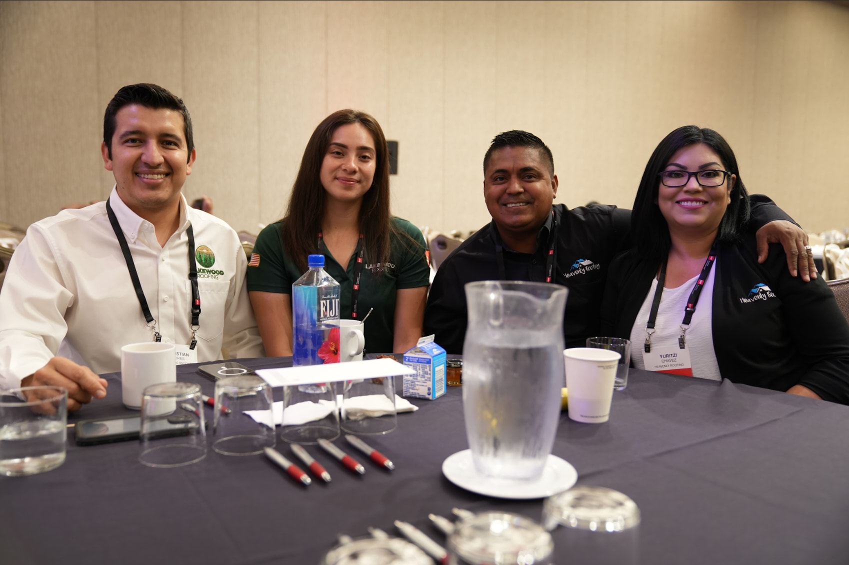 latinos in roofing 2023 attendees at table A group of 4 LIR Expo attendees smile at an event table together.