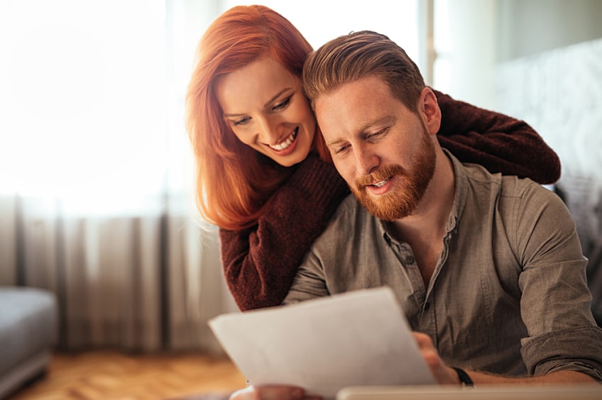 A young couple looking at a roof proposal in their home