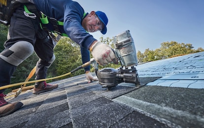 Roofer installing GAF shingles on a roof