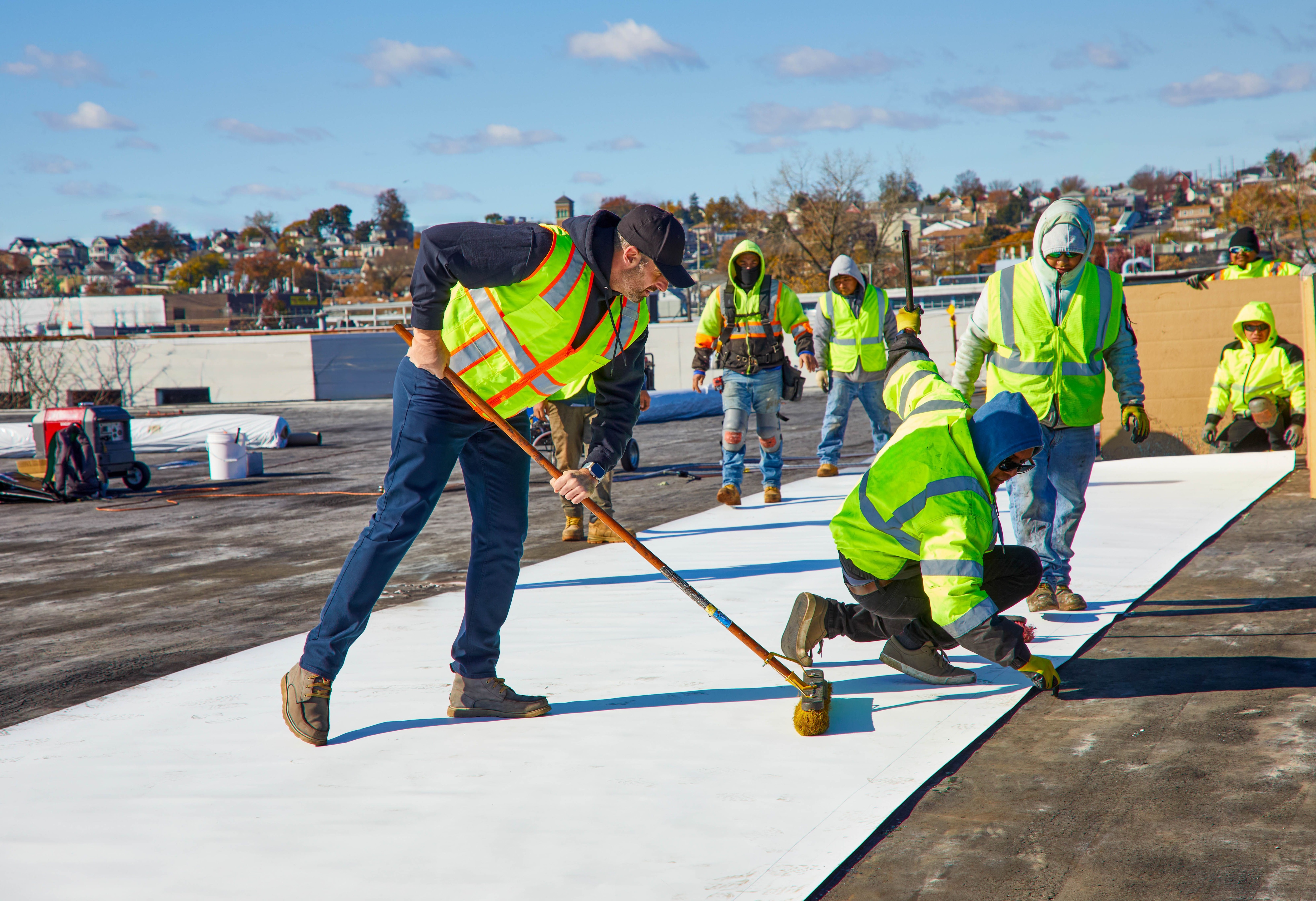 Roofers installing a GAF single-ply roofing system in cold weather. 