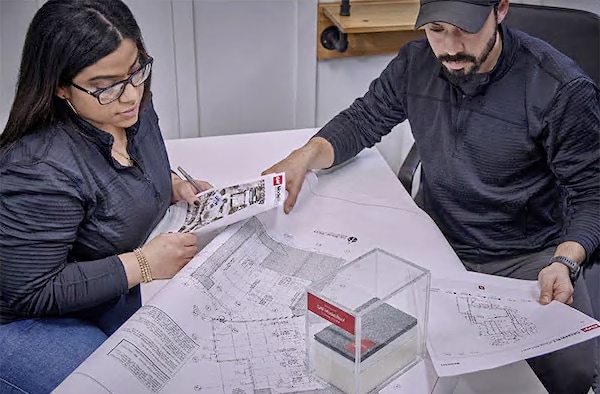 A GAF certified commercial contractor reviewing plans and roof assembly with a colleague.