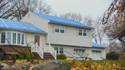 Image of storm-damaged roof with blue tarp on the roof