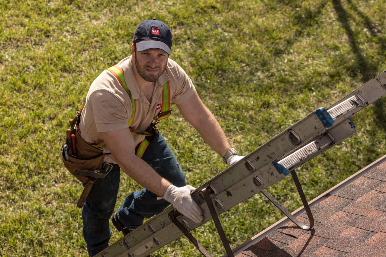 148eccda-3106-4de4-a64a-97f2abc0035f Roofer on a ladder inspecting a roof.