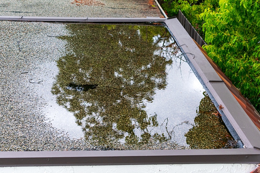 A brick chimney on a shingled roof