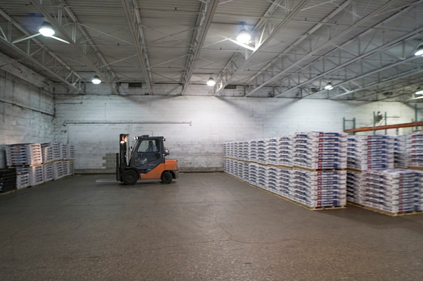 A roofer works with shingles on top of a roof