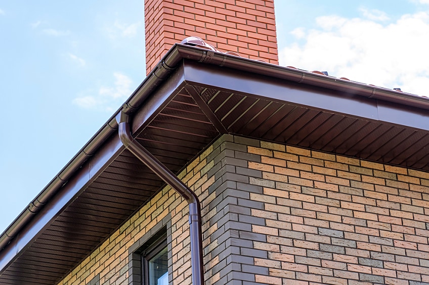 Close-up view of a Roof overhang with boxed eaves on a brick home.